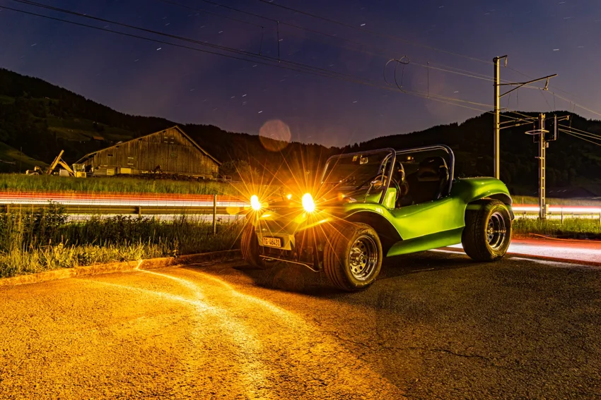 Saschas grüner Buggy mit eingeschalteten Scheinwerfern bei Nacht